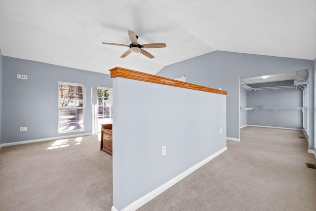 corridor featuring lofted ceiling, carpet flooring, and baseboards