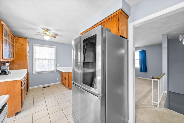 kitchen with brown cabinetry, light countertops, visible vents, and smart refrigerator