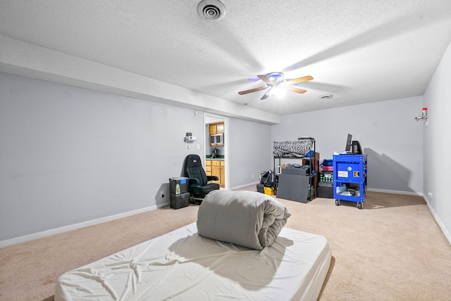 interior space featuring a textured ceiling, carpet, visible vents, and baseboards