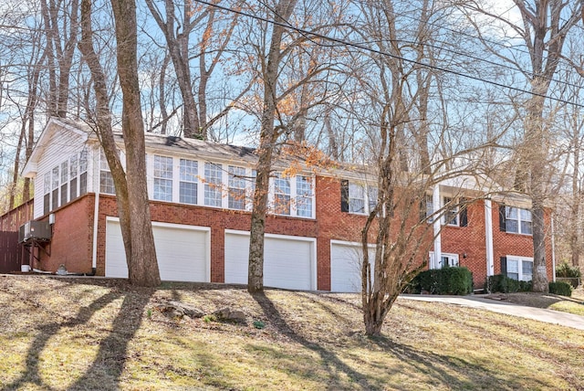 view of front of home featuring driveway, brick siding, and an attached garage