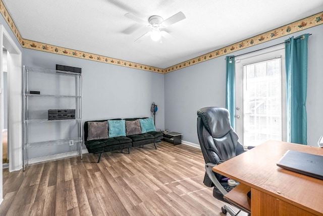 office space featuring a ceiling fan, baseboards, and wood finished floors