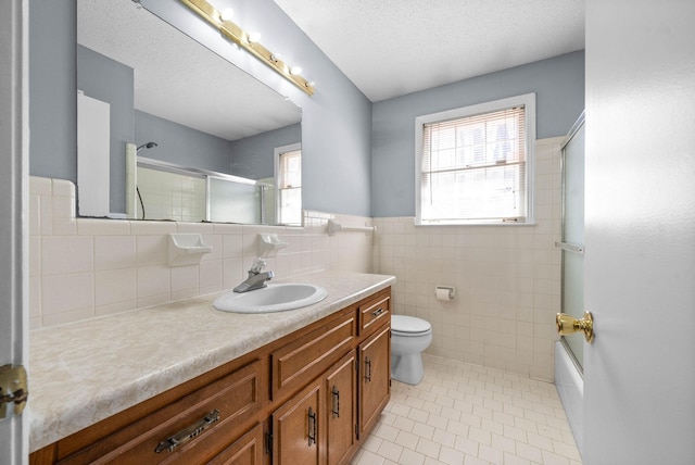 bathroom featuring tile walls, toilet, a textured ceiling, vanity, and tile patterned floors