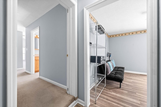 hallway with wood finished floors and baseboards