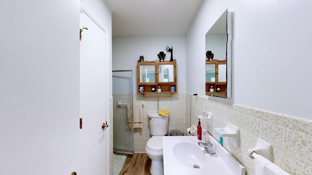 bathroom with hardwood / wood-style flooring, toilet, a shower with shower door, and sink