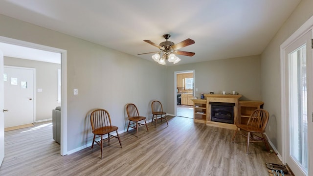 living area featuring ceiling fan and light hardwood / wood-style flooring