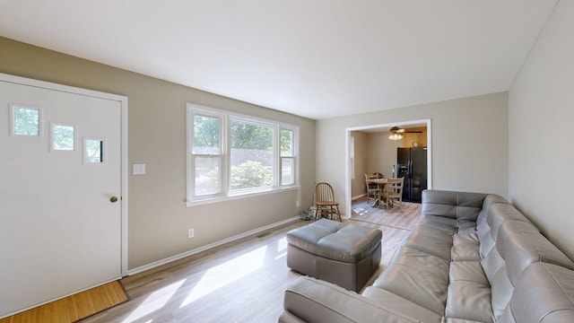 living room featuring light wood-type flooring and ceiling fan