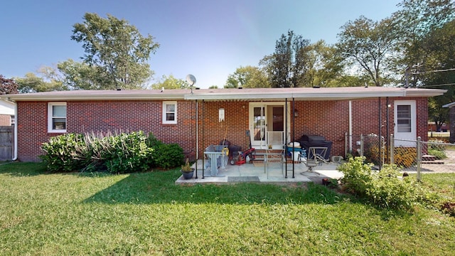 rear view of house featuring a yard and a patio