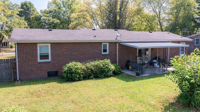 back of property with a yard and a patio