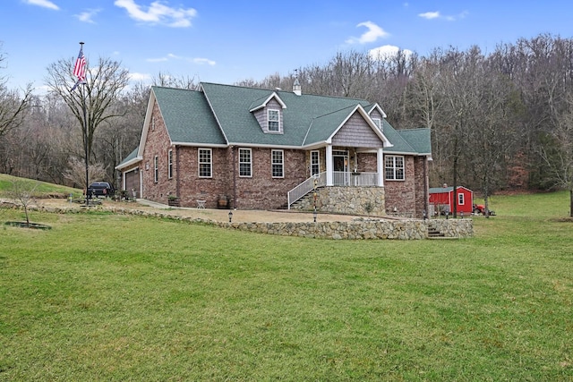 view of front of home featuring a front lawn, covered porch, a garage, and a storage unit