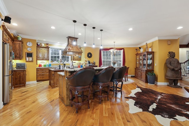 kitchen featuring stainless steel fridge, light hardwood / wood-style floors, hanging light fixtures, and an inviting chandelier