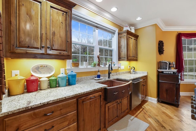 kitchen featuring stainless steel dishwasher, light stone counters, crown molding, sink, and light hardwood / wood-style flooring