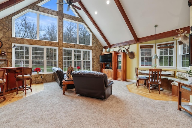 living room with beamed ceiling, carpet flooring, high vaulted ceiling, and ceiling fan