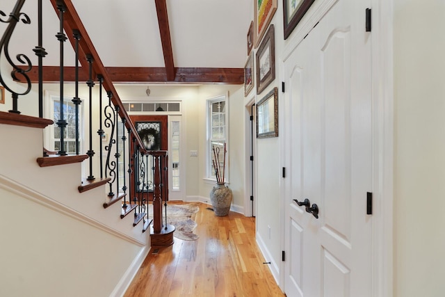 foyer with light hardwood / wood-style flooring and beamed ceiling