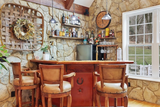 bar featuring beamed ceiling, decorative light fixtures, and wood-type flooring