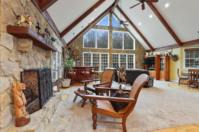 living room with ceiling fan, beamed ceiling, high vaulted ceiling, and plenty of natural light