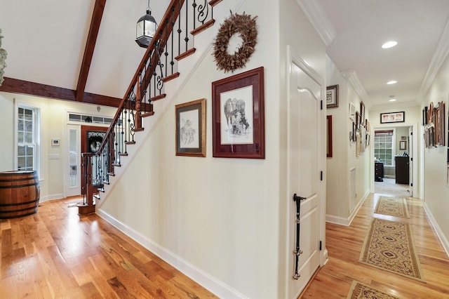 hall with lofted ceiling with beams, ornamental molding, and hardwood / wood-style flooring