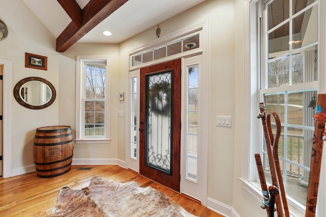 foyer featuring vaulted ceiling with beams and light wood-type flooring