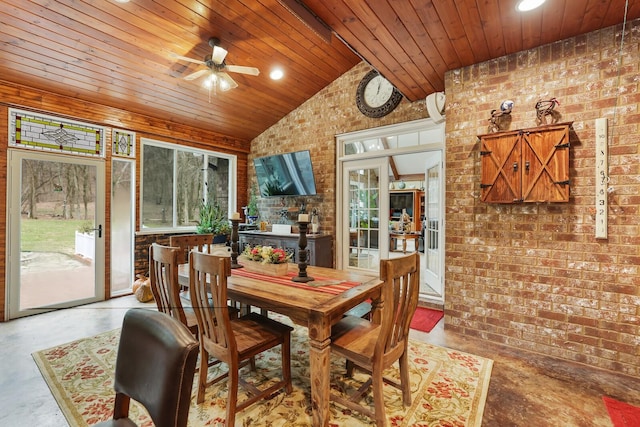 dining room with wood ceiling, concrete flooring, brick wall, vaulted ceiling, and ceiling fan