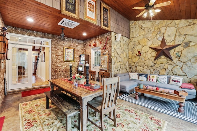 dining area with concrete flooring, ceiling fan, and wood ceiling