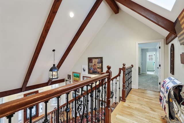 corridor featuring light hardwood / wood-style floors, beam ceiling, and high vaulted ceiling