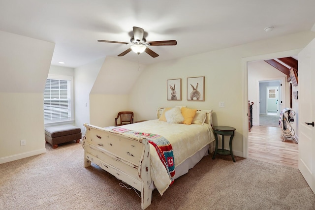 bedroom featuring ceiling fan, light carpet, and vaulted ceiling