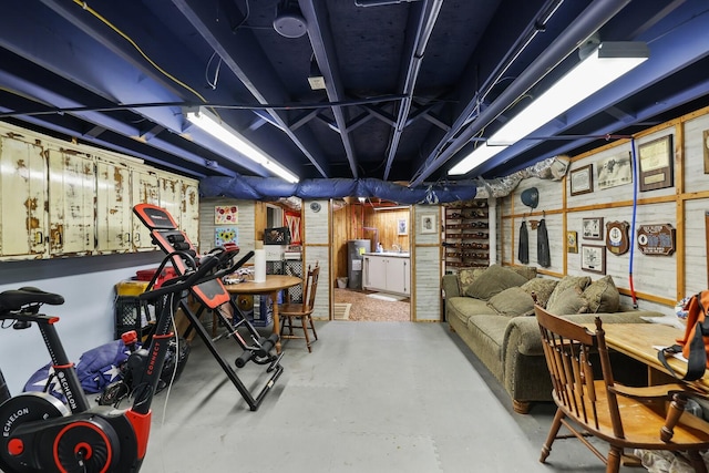 basement featuring wood walls and electric water heater