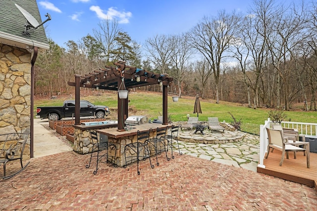 view of patio / terrace with a pergola, a grill, a bar, and an outdoor kitchen