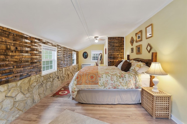 bedroom with lofted ceiling and light wood-type flooring