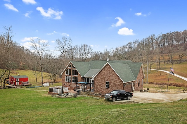 rear view of house with a yard, a garage, and a shed