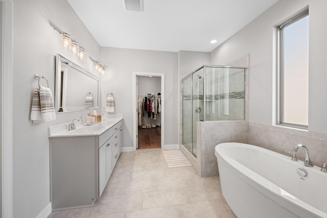 bathroom with plus walk in shower, vanity, and tile patterned flooring