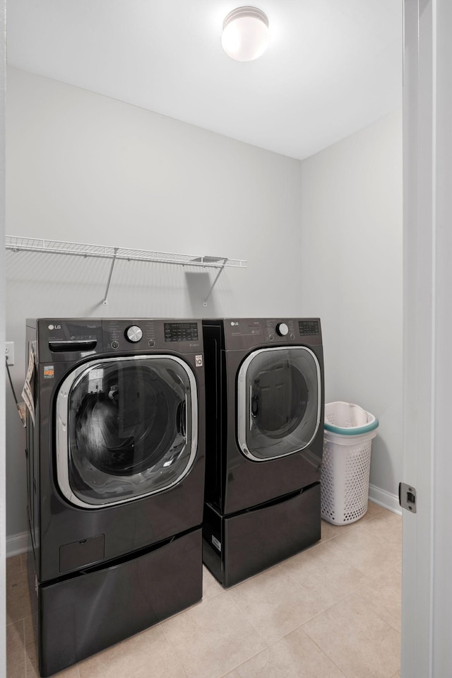 laundry area featuring independent washer and dryer and light tile patterned floors