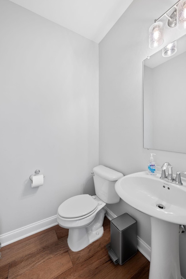 bathroom featuring toilet and wood-type flooring