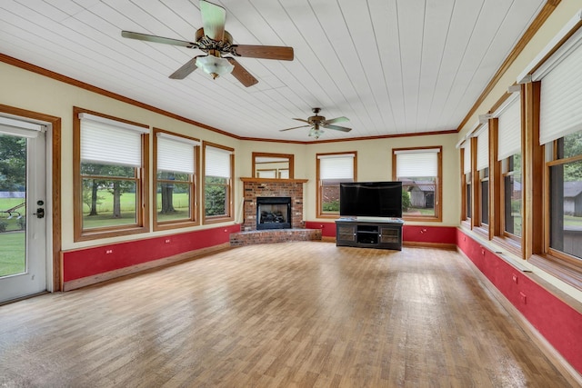 unfurnished sunroom featuring ceiling fan, wooden ceiling, and a brick fireplace