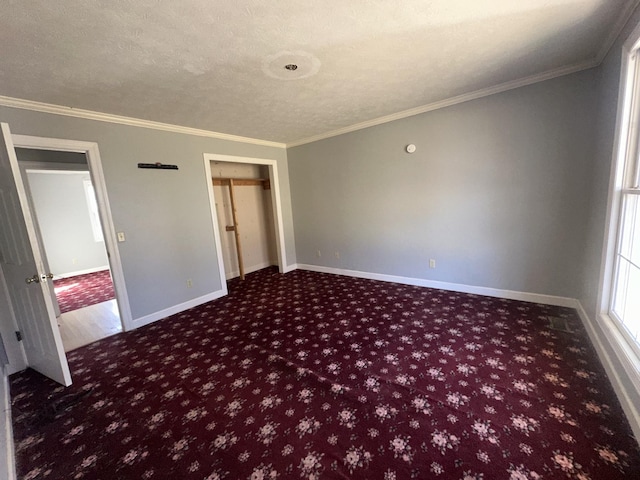 carpeted spare room with ornamental molding and a textured ceiling