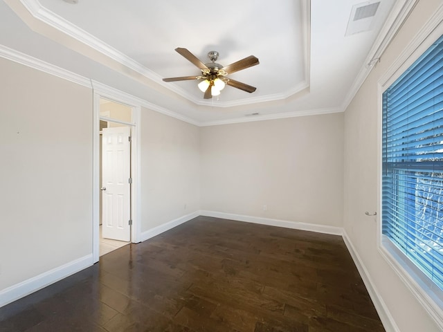 spare room featuring ceiling fan, dark hardwood / wood-style flooring, ornamental molding, and a tray ceiling