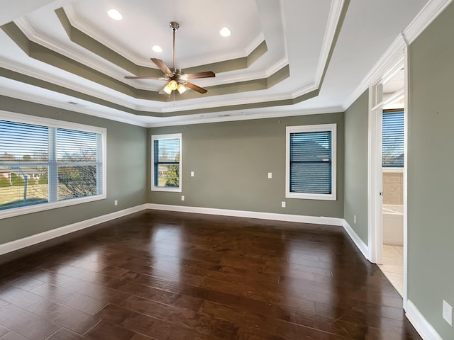 unfurnished room with a raised ceiling, ceiling fan, dark hardwood / wood-style flooring, and ornamental molding