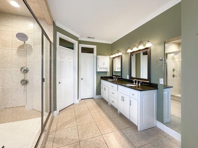 bathroom featuring tile patterned floors, vanity, a shower with door, and ornamental molding