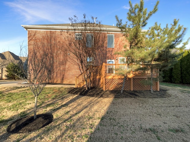 back of property with a lawn and a deck