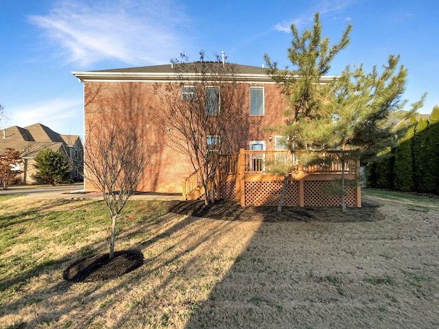 back of property with a yard and a wooden deck