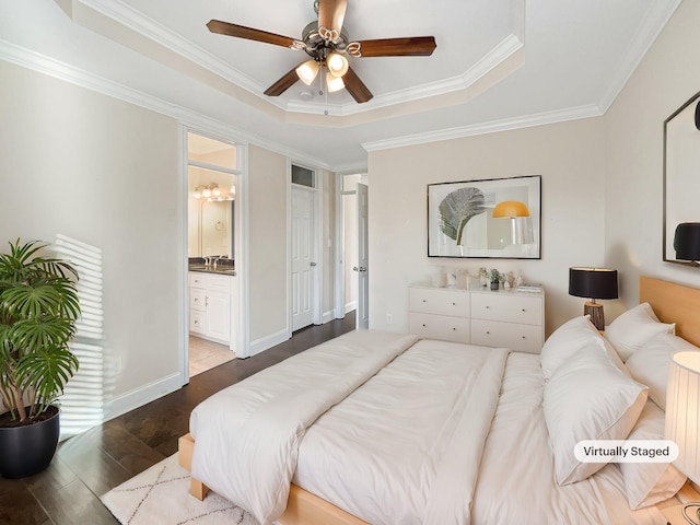 bedroom with a raised ceiling, crown molding, ensuite bath, ceiling fan, and dark hardwood / wood-style flooring