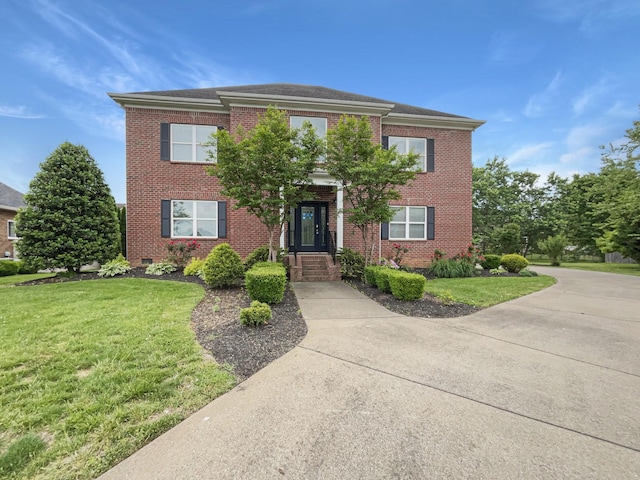 view of front of house with brick siding and a front lawn