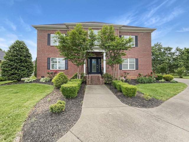 view of front facade with brick siding and a front lawn