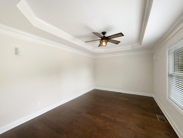 unfurnished room with a ceiling fan, dark wood-style flooring, ornamental molding, visible vents, and a raised ceiling