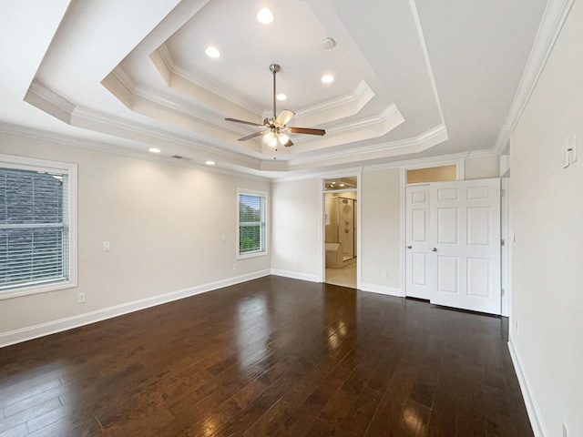 unfurnished bedroom with ornamental molding, a tray ceiling, and hardwood / wood-style flooring