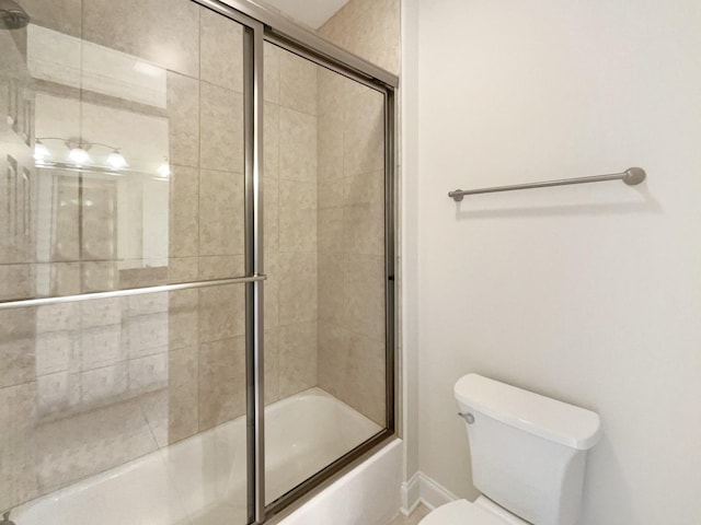 full bathroom featuring toilet, baseboards, and bath / shower combo with glass door