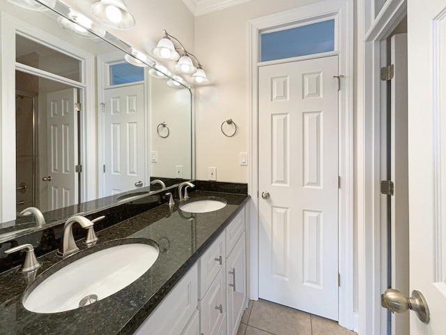 bathroom featuring a sink, crown molding, double vanity, and tile patterned floors