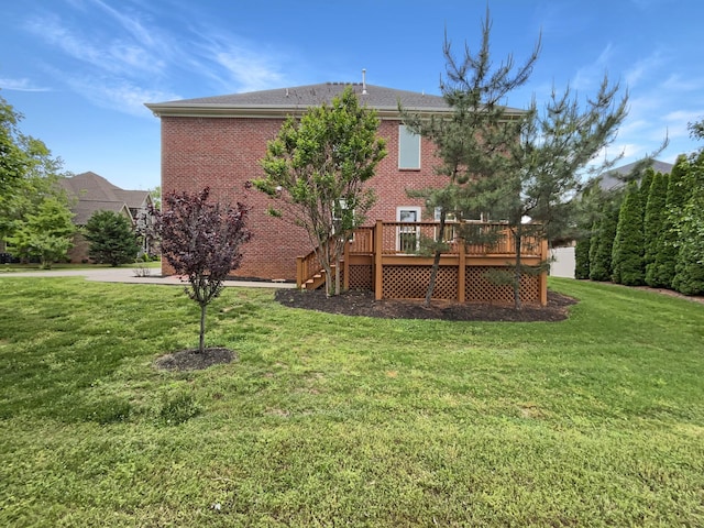 back of property featuring a lawn, brick siding, stairway, and a wooden deck