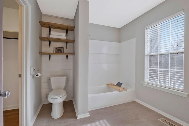 bathroom with toilet, tile patterned floors, and a bathtub