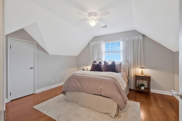 bedroom featuring hardwood / wood-style floors, vaulted ceiling, and ceiling fan