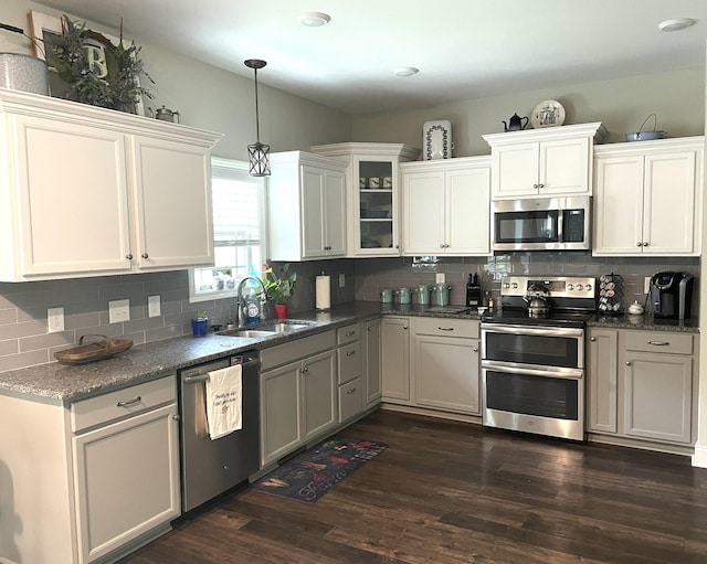 kitchen with dark hardwood / wood-style flooring, tasteful backsplash, stainless steel appliances, sink, and white cabinetry